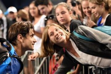 David Ferrer posa para una fotografía con una espectadora después de ganar a John Isner en el Open de Australia.