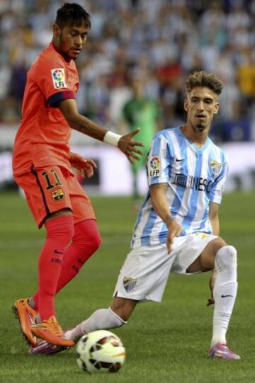 El delantero brasileño del FC Barcelona Neymar Da Silva lucha el balón con el delantero del Málaga CF Samuel Castillejo, durante el encuentro de la quinta jornada de Liga en Primera División que se disputa esta noche en el estadio de La Rosaleda, en Málaga.