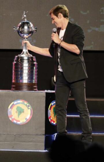 Venezuelan singer Carlos Baute holds the trophy after performing during the draw for the 2015 Copa Libertadores at the CONMEBOL headquarters in Luque, on the outskirts of Asuncion, December 2, 2014. REUTERS/Jorge Adorno (PARAGUAY - Tags: SPORT SOCCER ENTERTAINMENT)