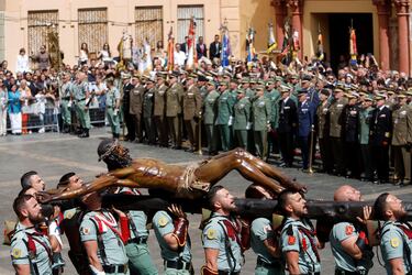El tercio Duque de Alba II de la Legión, con sede en Ceuta, en un momento del traslado del Cristo de la Buena Muerte y Ánimas, conocido como Cristo de Mena, a su trono procesional en el Jueves Santo a 6 de abril de 2023 en Málaga (Andalucía, España).  La Semana Santa es una de las celebraciones más importantes para los católicos, y en Sevilla se vive con especial fervor. Cerca de sesenta cofradías recorren las calles de la ciudad entre el Viernes de Dolores y el Domingo de Resurrección.