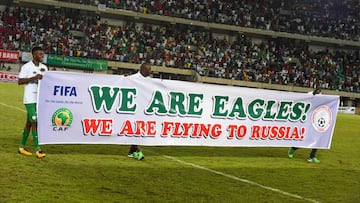 Nigerian players carry a banner to celebrate qualifying after the FIFA World Cup 2018 qualifying football match between Nigeria and Zambia in Uyo, Akwa Ibom State, on October 7, 2017.  / AFP PHOTO / PIUS UTOMI EKPEI