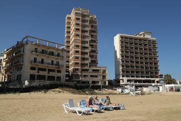 Cientos de edificios dentro del distrito de Varosha, que alguna vez fue un importante centro turstico chipriota, se encuentran abandonados y en decadencia en una zona que el ejrcito turco ha sellado desde que los residentes de Varosha huyeron en la guerra de 1974. Chipre ha estado dividido en un sur griego y un norte turco desde la breve pero devastadora guerra de 1974. Desde entonces, las fuerzas de paz de las Naciones Unidas han mantenido una zona de amortiguacin que atraviesa la ciudad capital de Nicosia y toda la isla para mantener separadas a las facciones. En el sur, la Repblica de Chipre, dominada por Grecia, est reconocida internacionalmente y es miembro de la Unin Europea, mientras que en el norte, la autoproclamada Repblica Turca del Norte de Chipre (RTNC) slo es reconocida por Turqua, que tambin tiene decenas de miles de tropas estacionadas all.