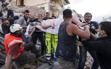 Una mujer es rescatada de entre los escombros de un edificio en Amatrice.