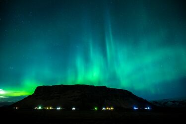 Espectacular vista de la aurora boreal sobre el monte Petursey en Vellir, cerca de Vik, en el sur de Islandia.