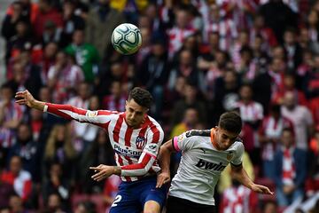 El jugador del Atlético, Mario Hermoso, y el jugador del Valencia, Ferran Torres pelean un balón de cabeza. 