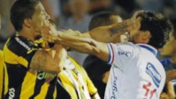 Futbolistas de Nacional y Peñarol se pelean en el clásico en enero de 2014.