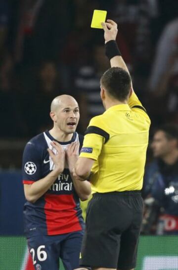 Christophe Jallet del Paris St Germain recibe una tarjeta amarilla del árbitro Ivan Bebek durante el partido de fútbol contra el Bayer Leverkusen en el Estadio Parc des Princes en París.