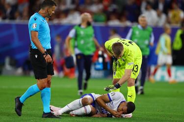 Patrick Pentz, portero austriaco, se interesa por el estado de Kylian Mbappé tras recibir un golpe en el rostro.