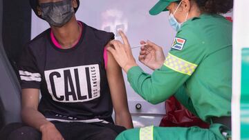 A young man is vaccinated by a member of the Western Cape Metro EMS(Emergency Medical Services) in an ambulance which has been converted to facilitate vaccinations at a COVID 19 vaccination event in Manenberg, which is part of the Vaxi-Taxi mobile vaccina