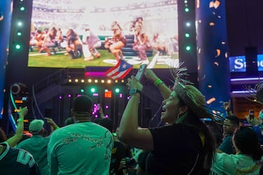 Aficionaods puertorriqueños bailan al ritmo de Bad Bunny durante el show del descanso viendo el espectáculo por pantallas gigantes en San Juan, Puerto Rico.