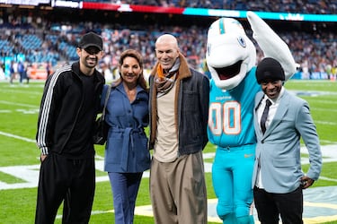 Zinedine Zidane, Veronique Zidane y Enzo Zidane posan junto a la mascota de los Miami Dolphins antes del inicio del partido.
