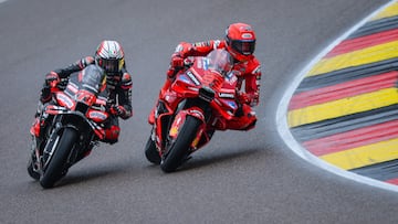 Ducati Lenovo Team's Spanish MotoGP rider Marc Marquez (R) overtakes Aprilia Racing team's Italian MotoGP rider Marco Bezzecchi on the last race lap during the sprint race of the MotoGP German motorcycle Grand Prix at the Sachsenring racing circuit, in Hohenstein-Ernstthal near Chemnitz, eastern Germany on July 12, 2025. (Photo by Ronny Hartmann / AFP)