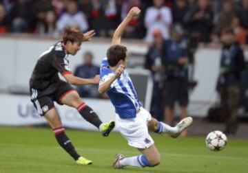El jugador del Bayer Leverkusen Son Heung-Min (izda) remata ante el defensa de la Real Sociedad Mikel Gonzalez