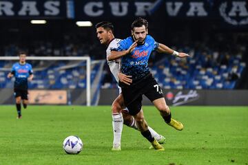 Bologna's Italian defender Kevin Bonifazi (L) and Napoli's Georgian forward Khvicha Kvaratskhelia go for the ball during the Italian Serie A footbal match between Napoli and Bologna on October 16, 2022 at the Diego-Maradona stadium in Naples. (Photo by Tiziana FABI / AFP)