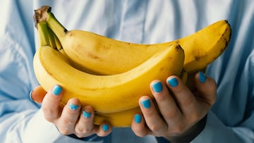 Ripe yellow bananas in the hands of a woman, bought at a shopping market. The concept of vegetarianism, veganism and raw food. Vegetarian, vegan food and diet. Fruits, food background. Retail sale of seasonal products. Plant food, ethical consumption.