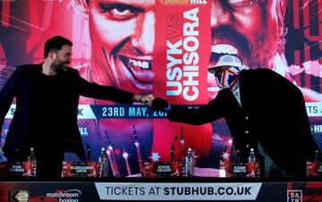 Londres. El promotor Eddie Hearn (izquierda) y el boxeador Dereck Chisora, chocan puños  tras la rueda de prensa de presentación del combate del inglés contra el ucraniano Olek Usyk. Chisora se presentó con guantes para evitar contagios.