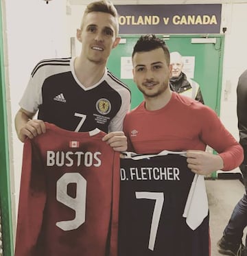 Bustos, tras un encuentro entre Canadá y Escocia, junto a Darren Fletcher, leyenda del Manchester United. Suma 19 presencias con su país, divididos entre la Sub 17, Sub 20 y adulta.