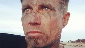 La cara tatuada del surfista Joe Crimo, con la playa al fondo.