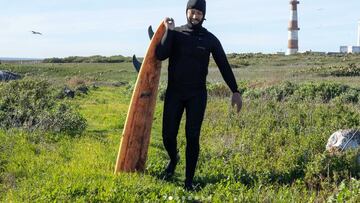 Coco Nogales en la isla de Todos Santos, México, con una tabla de surf naranja partida.