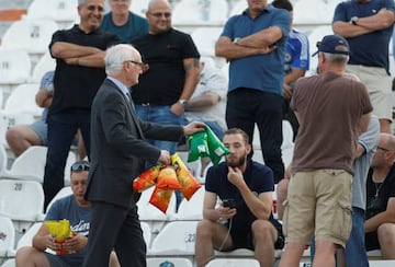 Bruce Buck, presidente del Chelsea, repartiendo bolsas de patatas entre los aficionados.