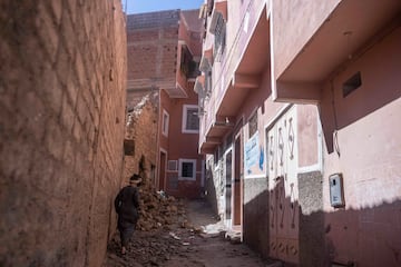 Una mujer camina entre los escombros afuera de su casa después de un terremoto en la aldea de Moulay Brahim, cerca de Marrakech, Marruecos,