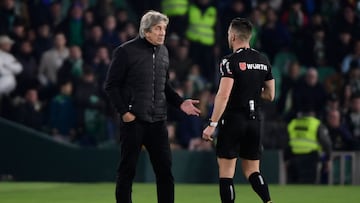 Real Betis' Chilean coach Manuel Pellegrini (L) talks with Spanish referee Carlos del Cerro Grande during the Spanish league football match between Real Betis and RC Celta de Vigo, at the Benito Villamarin stadium in Seville, on February 4, 2023. (Photo by CRISTINA QUICLER / AFP)