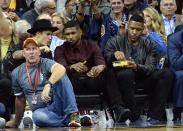 El cantante Justin Bieber con su colega Usher y el personaje de TV Michael Strahan, en el Quicken Loans Arena.