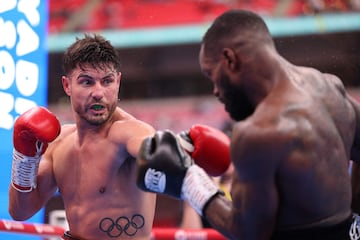 Josh Kelly (L) throws a punch during his win over Ishmael Davis in their middleweight boxing match at Wembley Stadium