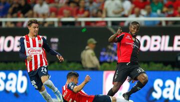 AME9015. GUADALAJARA (MÉXICO), 12/05/2022.- Carlos Cisneros (c) y Cristian Calderón (i) de Chivas disputa el balón con Julián Quiñones (d) de Atlas hoy, durante un partido de cuartos de final del torneo clausura 2022 de la liga de fútbol mexicano en el Estadio Akron, en Guadalajara, Jalisco (México). EFE/ Francisco Guasco
