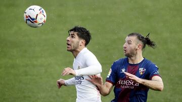Soccer Football - La Liga Santander - SD Huesca v Real Madrid - Estadio El Alcoraz, Huesca, Spain - February 6, 2021 Real Madrid's Marco Asensio in action with Huesca's Gaston Silva REUTERS/Albert Gea