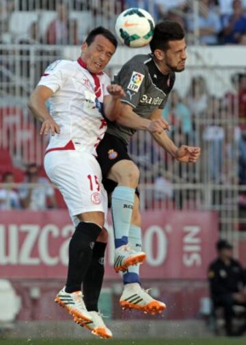 El centrocampista alemán del Servilla Piotr Trochowski (i) disputa un balón aéreo con el centrocampista Javi López (d).