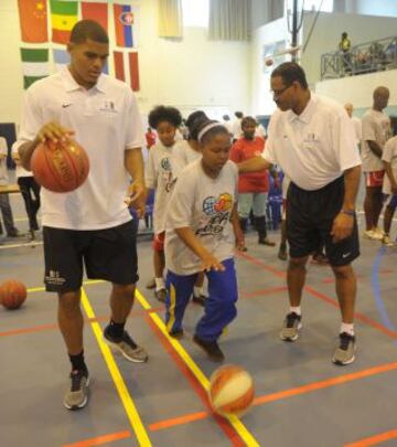 Tobias Harris, jugador de los Orlando Magic, ayuda en los ejercicios que hacen unas chicas.