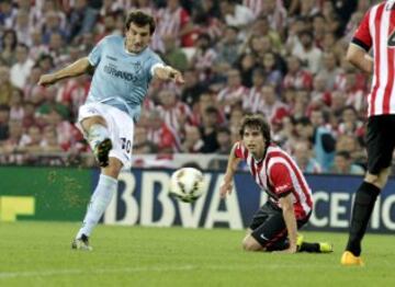 El delantero del Eibar Mikel Arruabarrena dispara a puerta ante la mirada del centrocampista del Athletic Club de Bilbao Ander Iturraspe, durante el partido de la sexta jornada de Liga en Primera Division que se juega esta noche en San Mamés. 