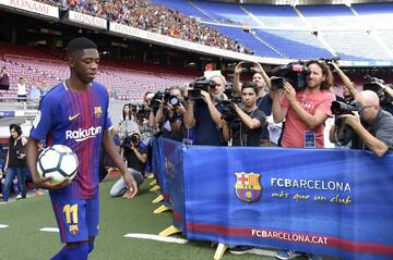 Barcelona's new player Ousmane Dembele (L) enters the pitch at the Camp Nou stadium in Barcelona, during his official presentation by the Catalan football club, on August 28, 2017