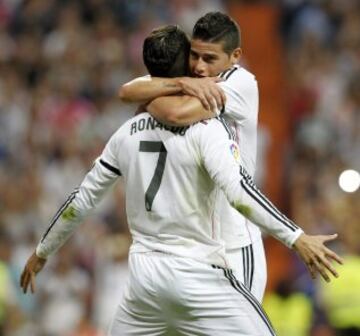 El delantero portugués del Real Madrid Cristiano Ronaldo (i) celebra con su compañero, el centrocampista colombiano James Rodríguez (d), el gol marcado de penalti al Atlético de Madrid, durante el partido de la tercera jornada de Liga de Primera División, disputado esta tarde en el estadio Santiago Bernabéu.