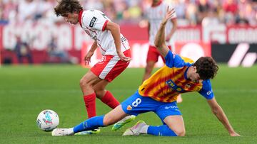 GIRONA, 04/10/2025.-El jugador del Valencia Javier Guerra, y el jugador del Girona Bryan Gi, durante el partido de la jornada 8 de la LaLiga EA Sports entre el Girona FC y el Valencia, este sábado en el estadio municipal de Montilivi.-EFE/ David Borrat
