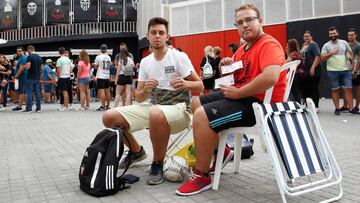 Dos aficionados del Valencia, con entradas para el derbi tras pasar casi toda la noche en las taquillas de Mestalla.