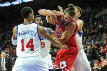 Joakim Noah, rodeado por tres jugadores de los Sixers.