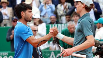 Italy's Jannik Sinner (R) shakes hands with Spain's Carlos Alcaraz after winning the Monte Carlo ATP Masters Series Tournament final tennis match on Court Rainier III at the Monte-Carlo Country Club in Roquebrune-Cap-Martin, south-eastern France on April 12, 2026. (Photo by Valery HACHE / AFP)