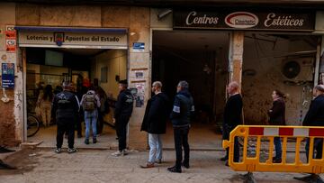 Varias personas hacen cola en una administración de lotería de Paiporta, a 13 de diciembre de 2024, en Paiporta, Valencia, Comunidad Valenciana (España). La zona cero de la DANA se enfrenta a la campaña de Navidad tras más de 40 días desde que las inundaciones arrasaran con casi la totalidad de los negocios, y dejaran tras de sí 222 víctimas mortales en la provincia de Valencia. Para la mayoría de las tiendas y restaurantes, las fiestas de navidad han quedado cubiertas por el fango.
13 DICIEMBRE 2024;PAIPORTA;NAVIDAD
Rober Solsona / Europa Press
13/12/2024