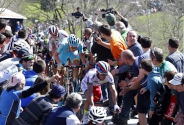 Varios ciclistas se abren paso entre la gente hoy en el Alto de La Antigua, en la localidad guipuzcoana de Zumarraga, durante la tercera etapa de la 55 edición de la Vuelta al País Vasco.