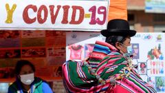 A Bolivian woman walks past a stand that provides information on diets in relationship to the coronavirus disease (COVID-19), as authorities have started to vaccinate people who make a living crossing the border between Bolivia and Peru, in Desaguadero, Bolivia May 21, 2021. Picture taken May 21, 2021. REUTERS/Claudia Morales NO RESALES. NO ARCHIVES