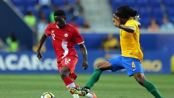Jul 7, 2017; Harrison, NJ, USA; Canada midfielder Alphonso Davies (12) plays the ball against French Guiana forward Rhudy Evens (4) during the first half at Red Bull Arena. Mandatory Credit: Brad Penner-USA TODAY Sports