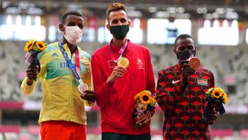 Tokyo 2020 Olympics - Athletics - Men&#039;s 3000m Steeplechase - Medal Ceremony - Olympic Stadium, Tokyo, Japan - August 3, 2021. Gold medallist Soufiane Elbakkali of Morocco celebrates on the podium with silver medallist, Lamecha Girma of Ethiopia and b