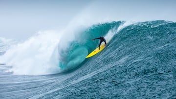 El Piojo Navarro surfeando una ola gigante, perfecta y con tubo en Punta de Lobos (Chile) con una tabla de surf amarilla.