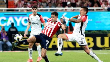 Alan Mozo (L) of Guadalajara fights for the ball with Uros Durdevic (R) of Atlas during the Liga MX Apertura tournament football match between Guadalajara and Atlas at the Akron stadium in Guadalajara, Jalisco State, Mexico, on November 21, 2024. (Photo by ULISES RUIZ / AFP)