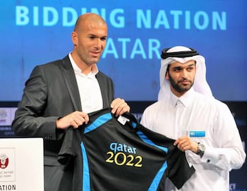 Hassan Al-Thawadi (R) presents the new official ambassador Zinedine Zidane, former France International and World cup winner with a personalised shirt during a press conference at the Four Seasons hotel in Doha, Qatar, 16 September 2010