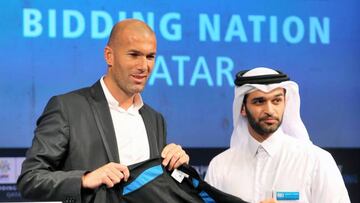 Hassan Al-Thawadi (R) presents the new official ambassador Zinedine Zidane, former France International and World cup winner with a personalised shirt during a press conference at the Four Seasons hotel in Doha, Qatar, 16 September 2010