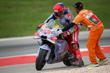 Marc Marquez recibe la ayuda de un operario para subirse a la moto y tratar de seguir en carrera.