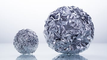 Two Big and Small Foil Balls with Reflection Against White Background.